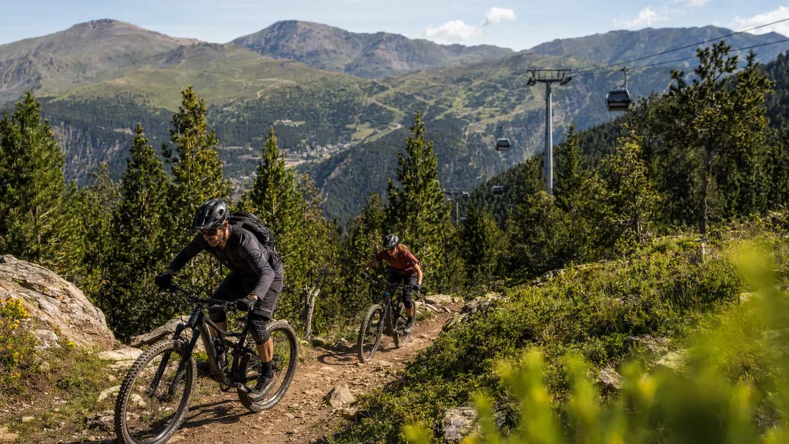 Mountain bikers riding summer trails near Arinsal