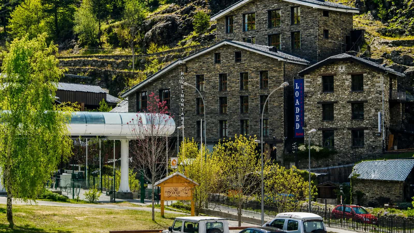Hotel Montané in summer with sunlit Pyrenean mountains around Arinsal